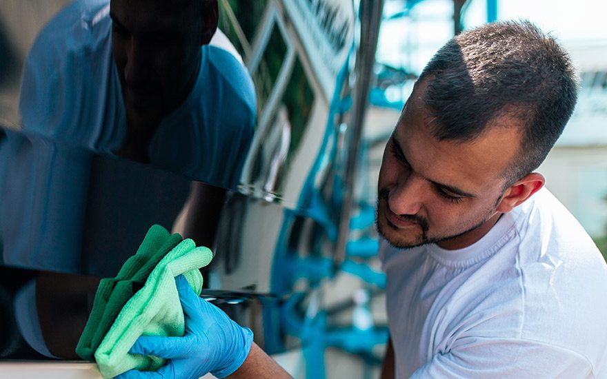 Man cleaning side of boat